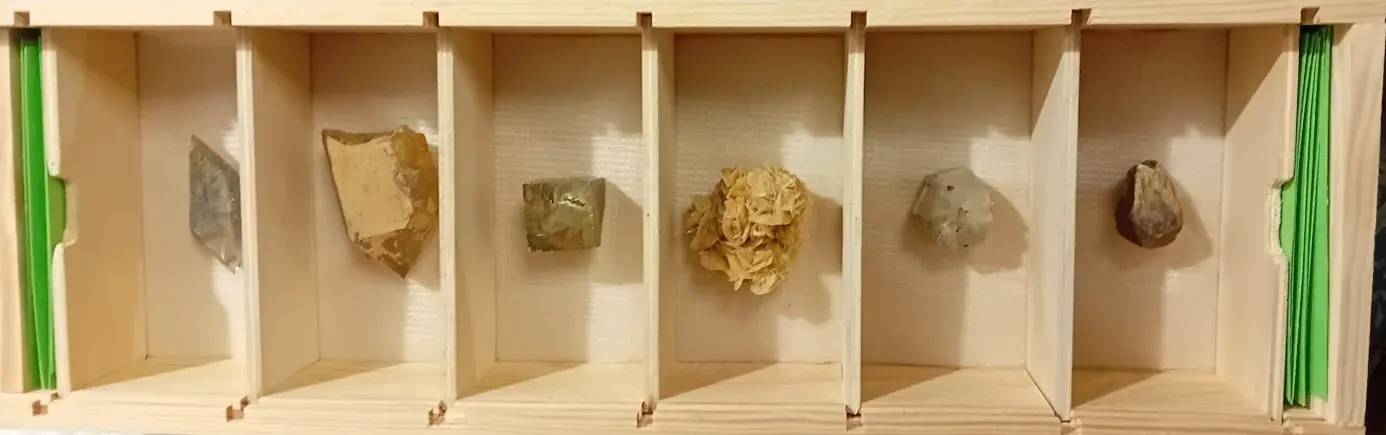 Boîte en bois avec casier où sont placés les pierres