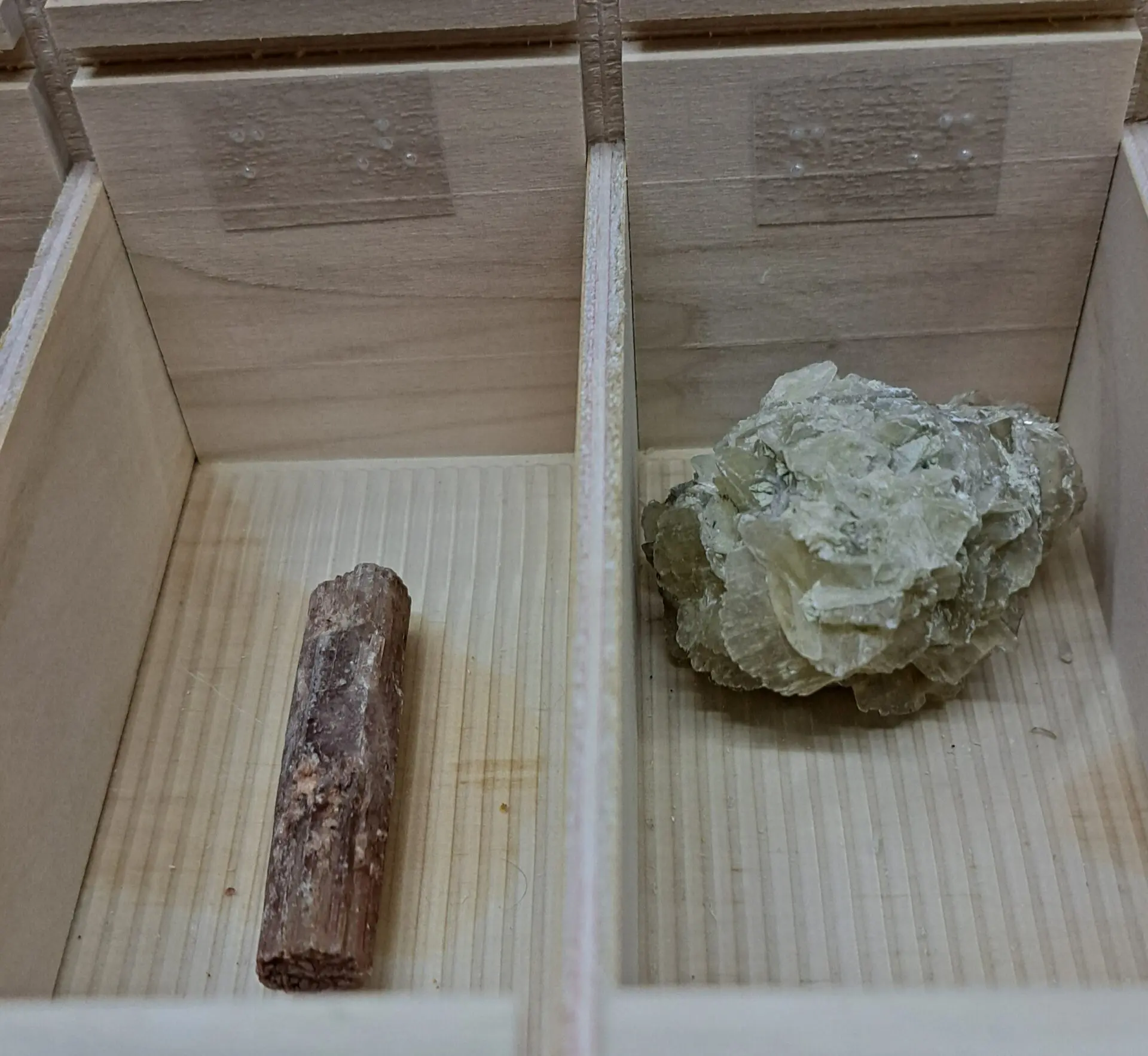 Deux pierres placées dans les casiers de l'une des boîtes avec repères braille sur le bord de la boîte.