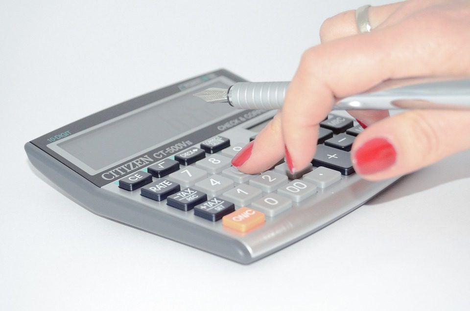 Main féminine qui tape sur une calculatrice