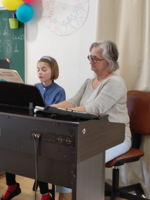 Anne au clavier accompagnée de sa professeure