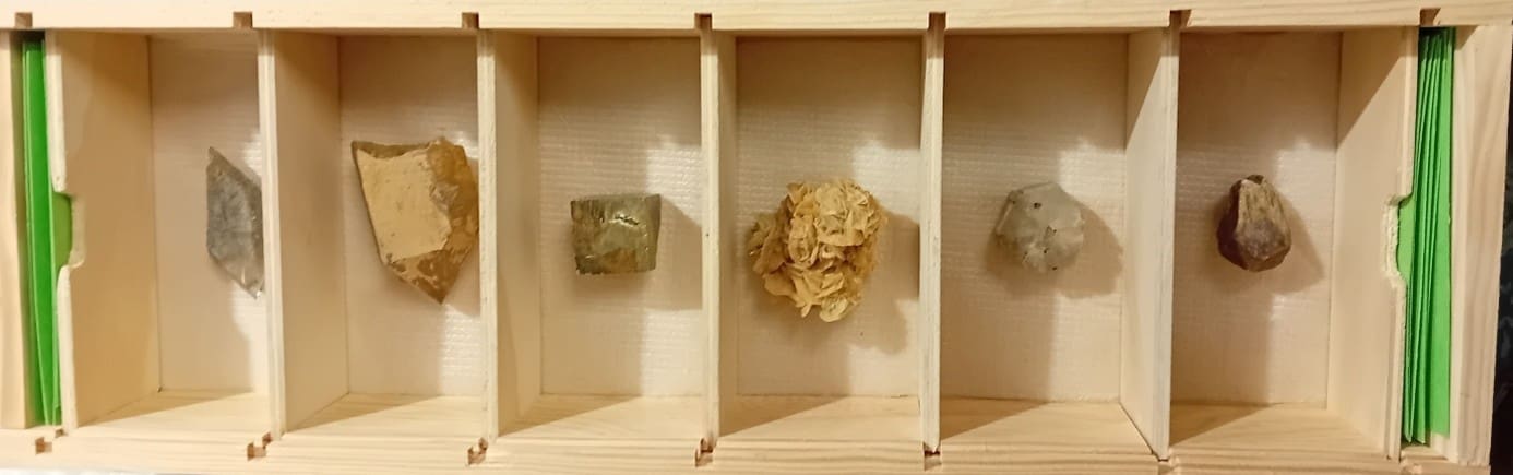 Boîte en bois avec casier où sont placés les pierres