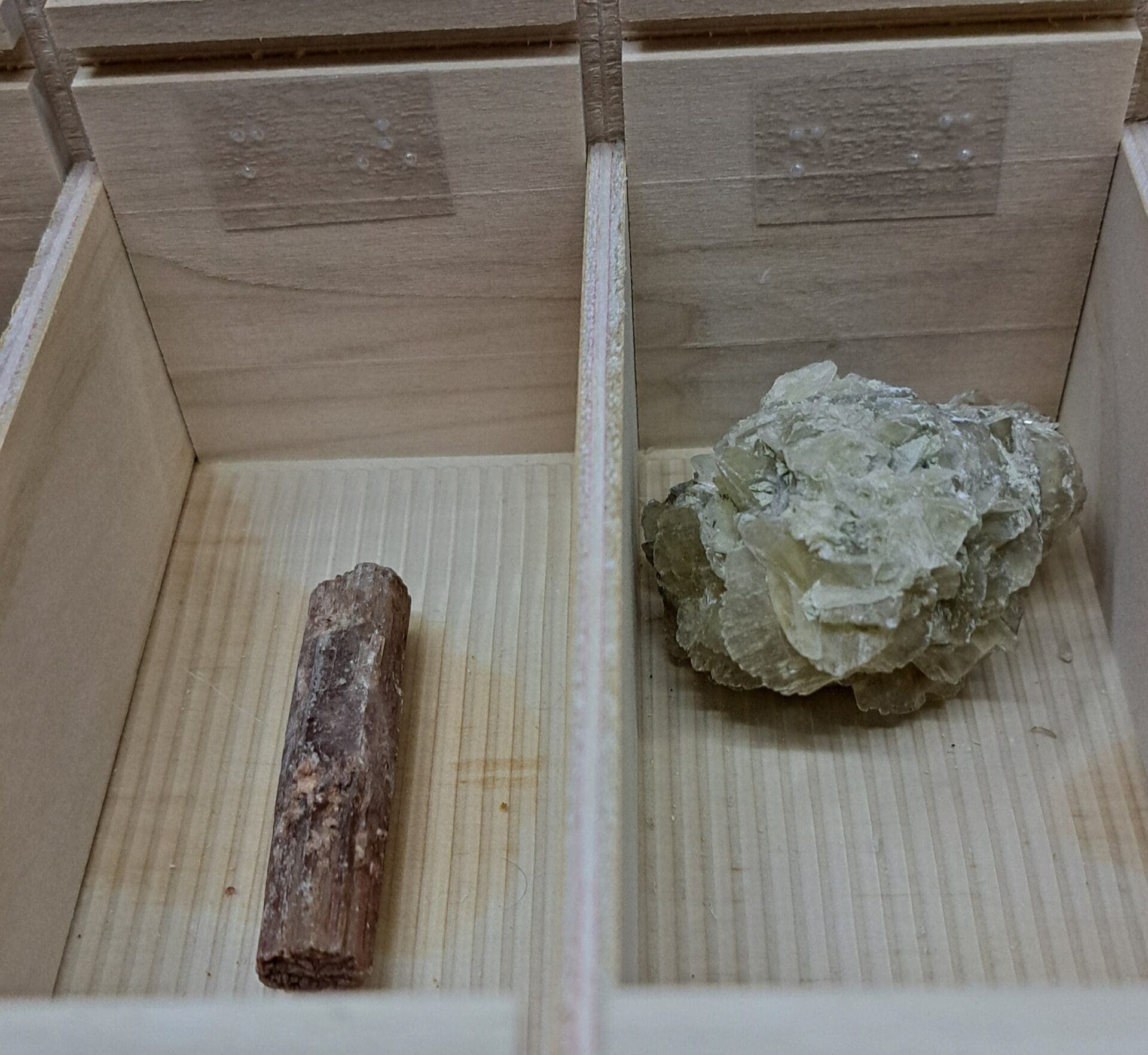 Deux pierres placées dans les casiers de l'une des boîtes avec repères braille sur le bord de la boîte.